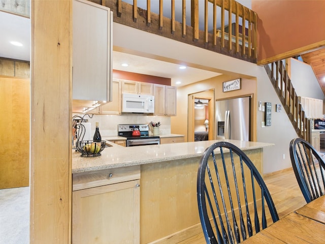 140 Boones Trl, Pocono Pines, PA 18350 - kitchen with stainless steel appliances, light brown cabinets, light stone countertops, light wood finished floors, and recessed lighting