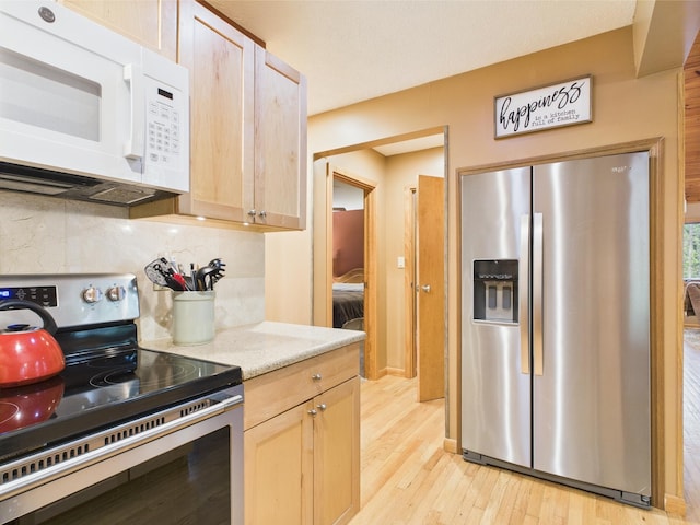 140 Boones Trl, Pocono Pines, PA 18350 - kitchen with appliances with stainless steel finishes, backsplash, light wood-style flooring, light countertops, and light brown cabinetry