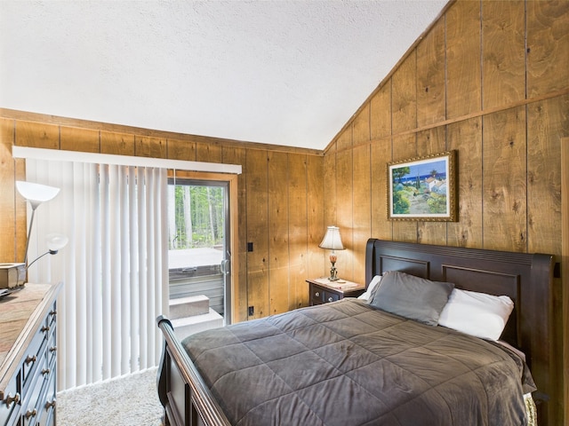 140 Boones Trl, Pocono Pines, PA 18350 - carpeted bedroom featuring vaulted ceiling, access to exterior, wooden walls, and a textured ceiling