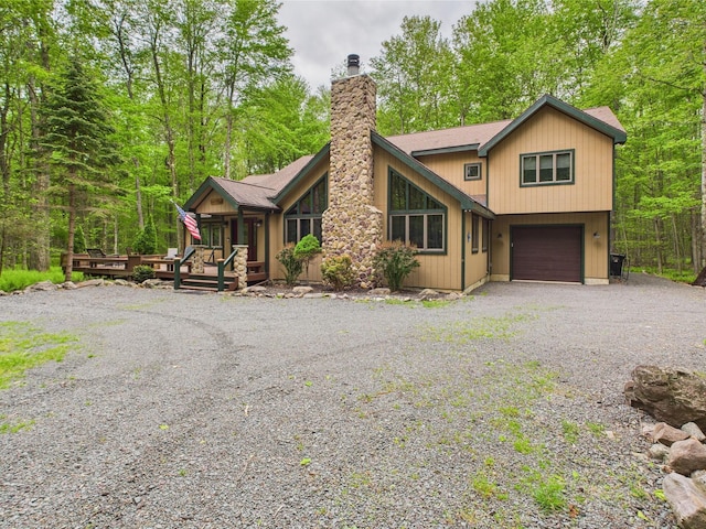140 Boones Trl, Pocono Pines, PA 18350 - rustic home featuring a chimney, gravel driveway, an attached garage, and a wooden deck
