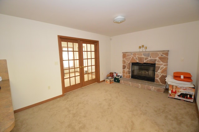 141 Fergus Way, Tobyhanna, PA 18466 - unfurnished living room with french doors, carpet, and a stone fireplace