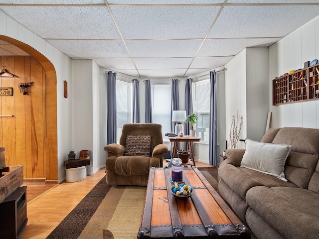 210 N Schanck Ave, Pen Argyl, PA 18072 - living area featuring light wood finished floors, a paneled ceiling, arched walkways, and wood walls