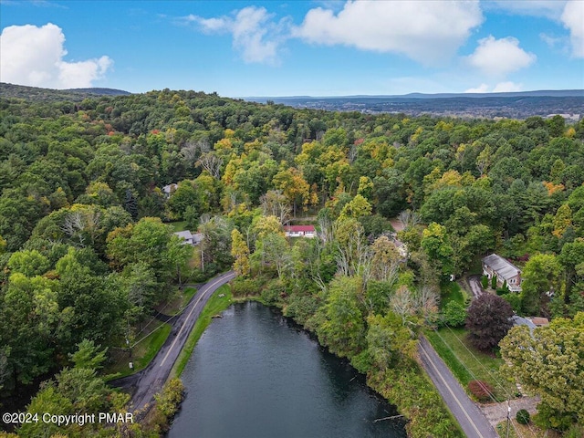 aerial view with a forest view and a water view