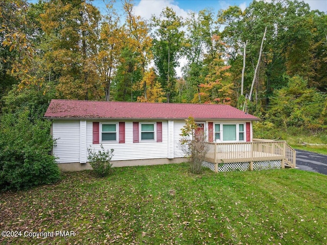 single story home featuring a deck and a front lawn