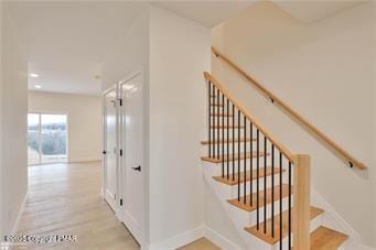 stairs featuring wood finished floors and baseboards