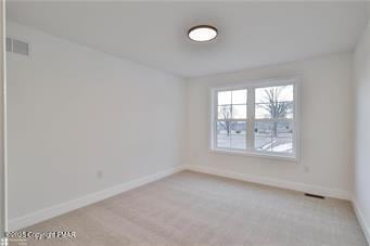 unfurnished room with carpet, visible vents, and baseboards