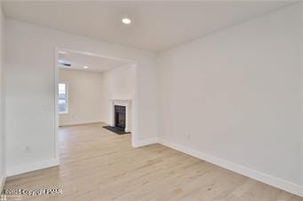 unfurnished living room featuring light wood-style flooring, a fireplace, baseboards, and recessed lighting