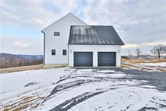 view of snowy exterior with a garage