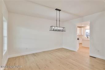 unfurnished dining area with baseboards and wood finished floors