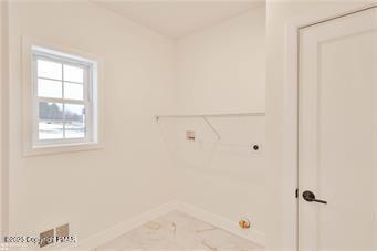 clothes washing area with baseboards and hookup for an electric dryer