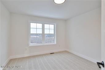 carpeted spare room featuring baseboards