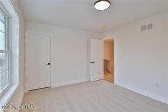 empty room featuring baseboards and visible vents