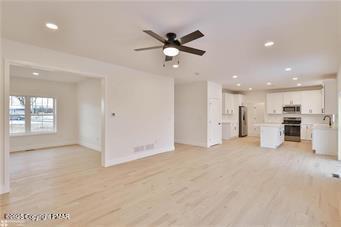 unfurnished living room featuring a ceiling fan, recessed lighting, and light wood-style flooring