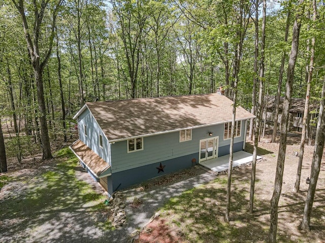 235 White Pine Ln, Pocono Lake, PA 18347 - view of front of property featuring a chimney, roof with shingles, and a wooded view
