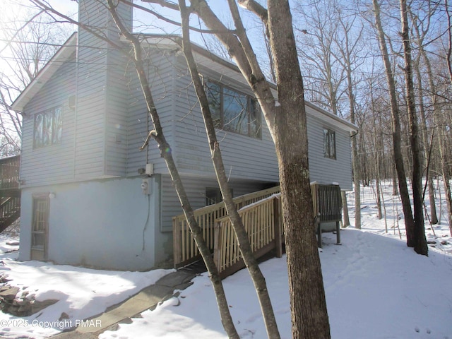 snow covered property featuring stairs