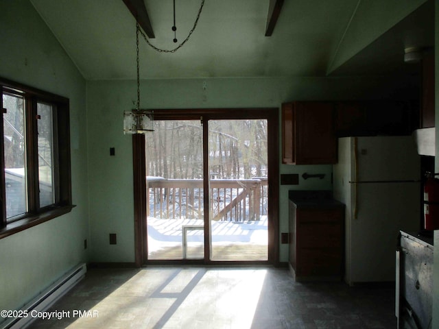 dining space with a baseboard radiator, baseboards, and vaulted ceiling