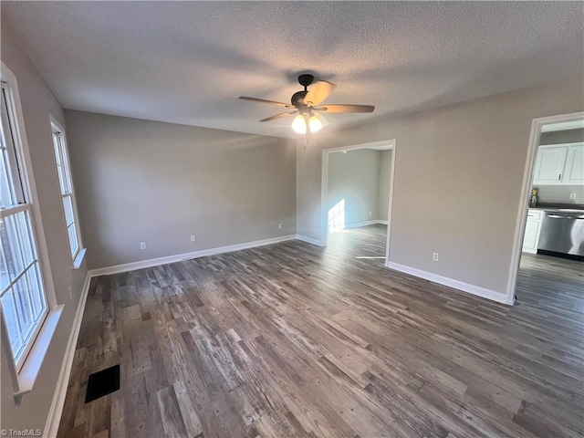 spare room with ceiling fan, a textured ceiling, and dark hardwood / wood-style floors