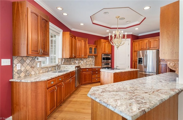 kitchen featuring light stone countertops, a center island, pendant lighting, appliances with stainless steel finishes, and light hardwood / wood-style floors