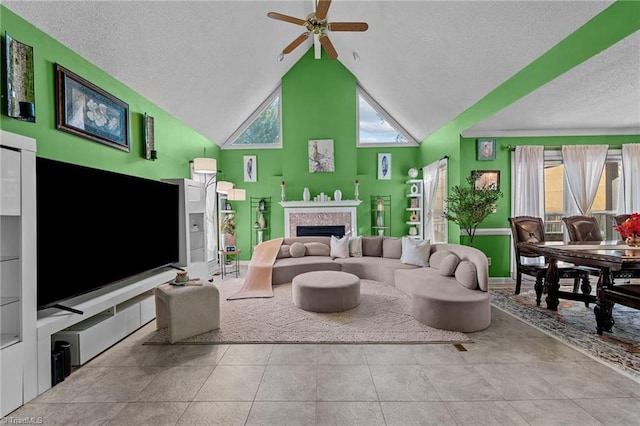 living area featuring a ceiling fan, tile patterned flooring, a textured ceiling, a fireplace, and high vaulted ceiling