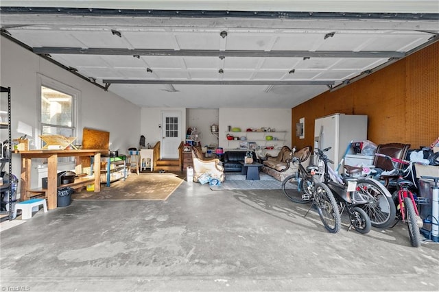 garage featuring white refrigerator with ice dispenser