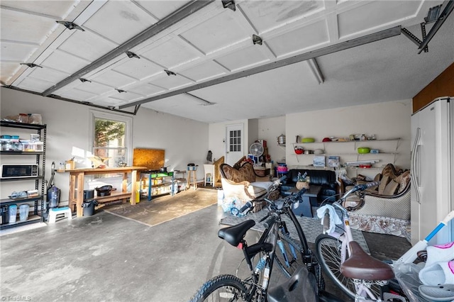 garage featuring a workshop area and freestanding refrigerator