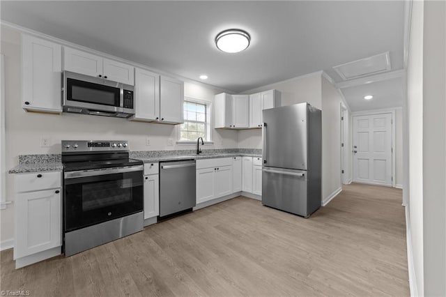 kitchen with white cabinetry, sink, stainless steel appliances, light stone countertops, and light hardwood / wood-style flooring