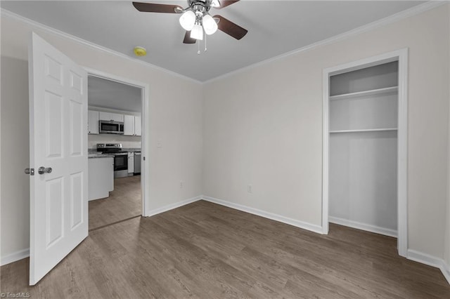 unfurnished bedroom with crown molding, ceiling fan, light wood-type flooring, and a closet