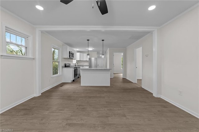 kitchen featuring pendant lighting, white cabinets, a center island, stainless steel appliances, and crown molding