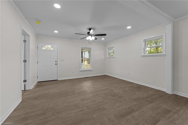 empty room featuring crown molding, dark hardwood / wood-style floors, and a wealth of natural light