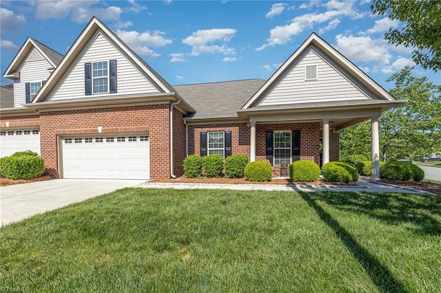 view of front of house featuring a porch, brick siding, driveway, and a front yard
