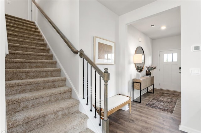 entryway featuring wood finished floors, stairway, and baseboards