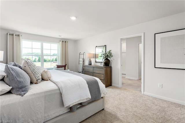 bedroom featuring light carpet and baseboards