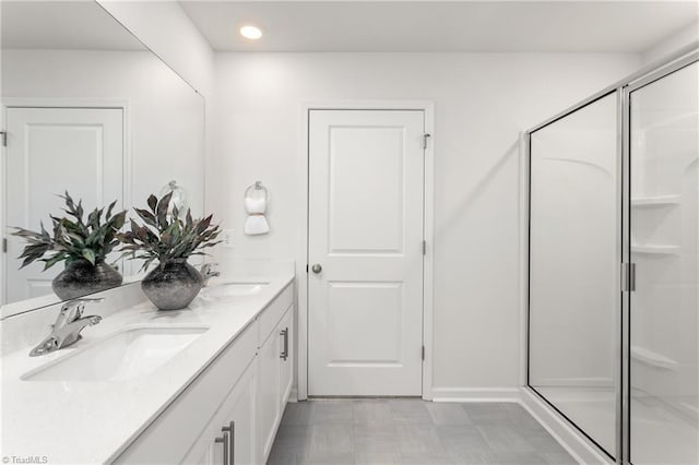 bathroom with a shower stall, double vanity, recessed lighting, and tile patterned floors