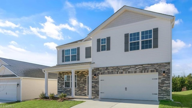 view of front facade featuring stone siding, concrete driveway, an attached garage, and a front lawn