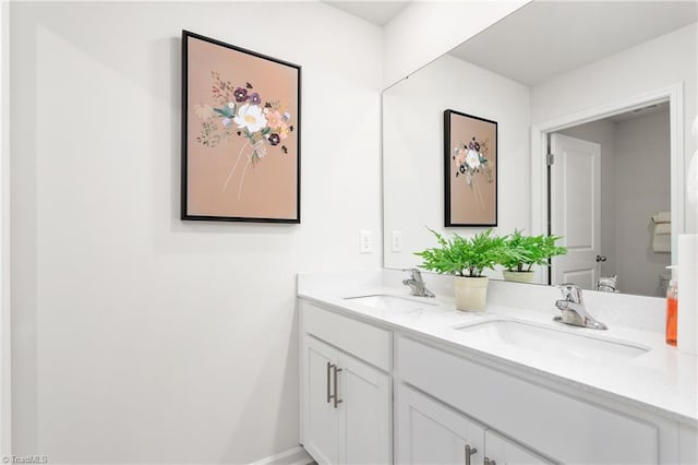 full bathroom with double vanity, toilet, and baseboards