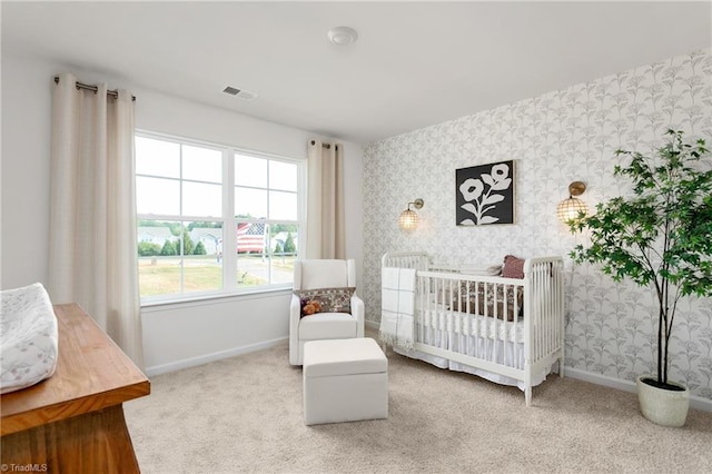 bedroom with wallpapered walls, carpet, baseboards, and a crib