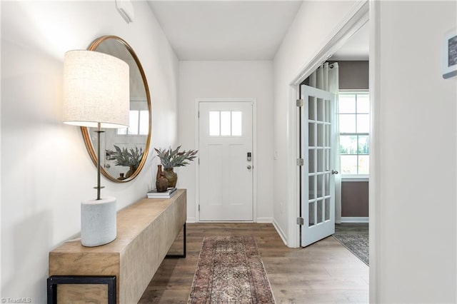 entryway with wood finished floors and baseboards