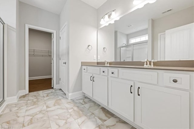 bathroom with vanity, a stall shower, marble finish floor, visible vents, and baseboards