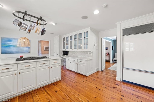 948 Kenleigh Cir, Winston-Salem, NC 27106 - kitchen featuring paneled built in fridge, stainless steel gas cooktop, light wood-type flooring, decorative backsplash, and white cabinetry