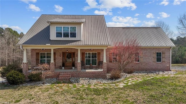 4420 Bunton Swaim Rd, Liberty, NC 27298 - view of front of property featuring a front yard, covered porch, brick siding, and metal roof