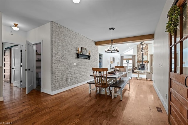 4420 Bunton Swaim Rd, Liberty, NC 27298 - dining room with visible vents, brick wall, vaulted ceiling with beams, baseboards, and wood finished floors