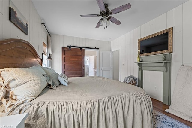 4420 Bunton Swaim Rd, Liberty, NC 27298 - bedroom featuring ceiling fan, a barn door, and wood finished floors