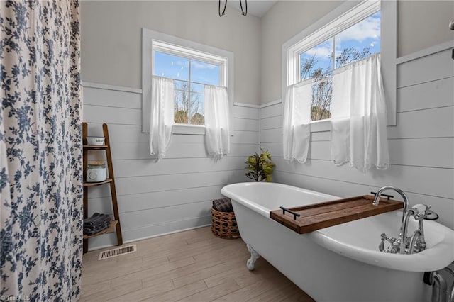 4420 Bunton Swaim Rd, Liberty, NC 27298 - bathroom with wood finished floors, visible vents, wood walls, and a freestanding bath