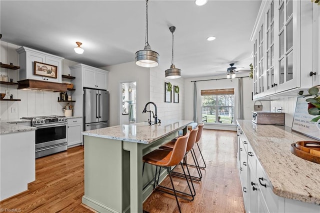 4420 Bunton Swaim Rd, Liberty, NC 27298 - kitchen featuring light wood finished floors, open shelves, ceiling fan, a sink, and appliances with stainless steel finishes