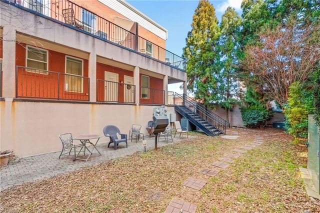 rear view of house with stairs and a patio