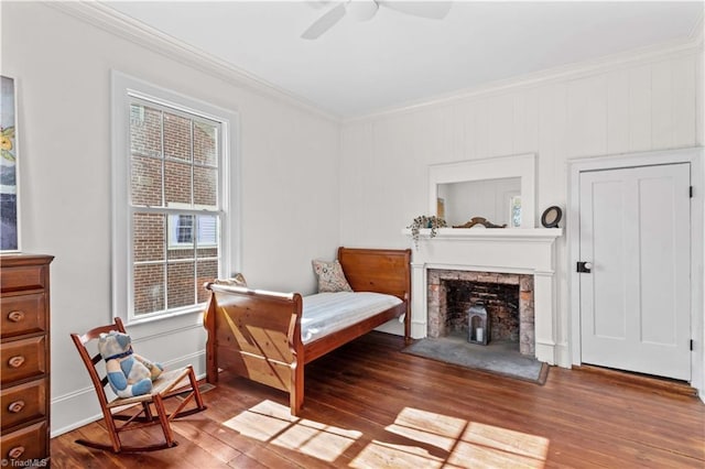 sitting room featuring baseboards, wood finished floors, a ceiling fan, and crown molding