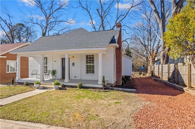 bungalow-style house featuring roof with shingles, a chimney, a porch, a front yard, and fence