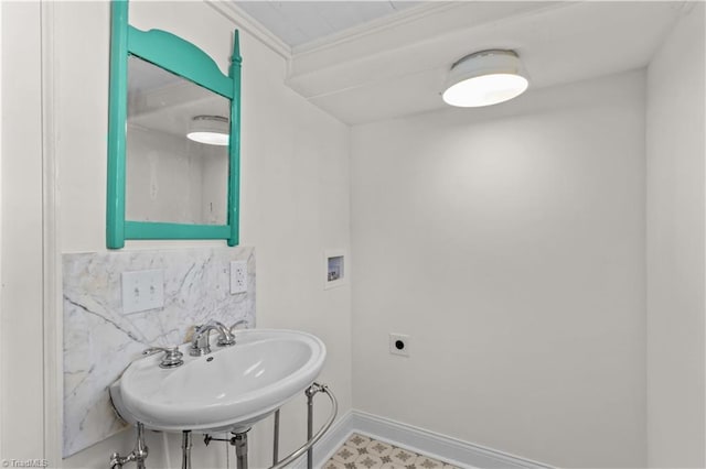 bathroom with baseboards, backsplash, and a sink