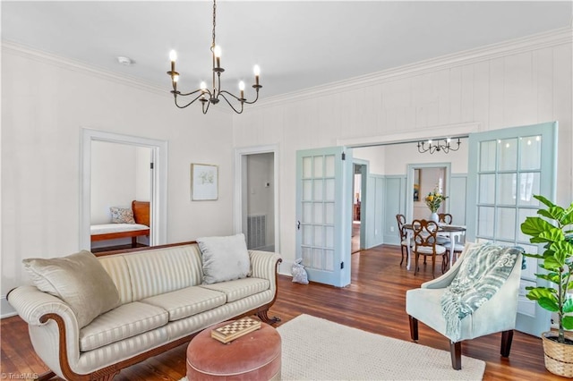 living area with an inviting chandelier, crown molding, and wood finished floors