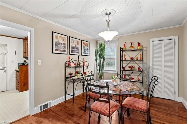 dining room featuring hardwood / wood-style floors and ornamental molding